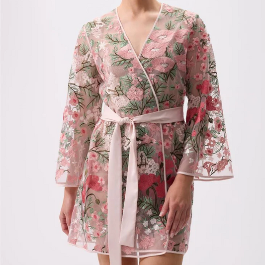 Woman wearing a floral kimono-style robe on a white background