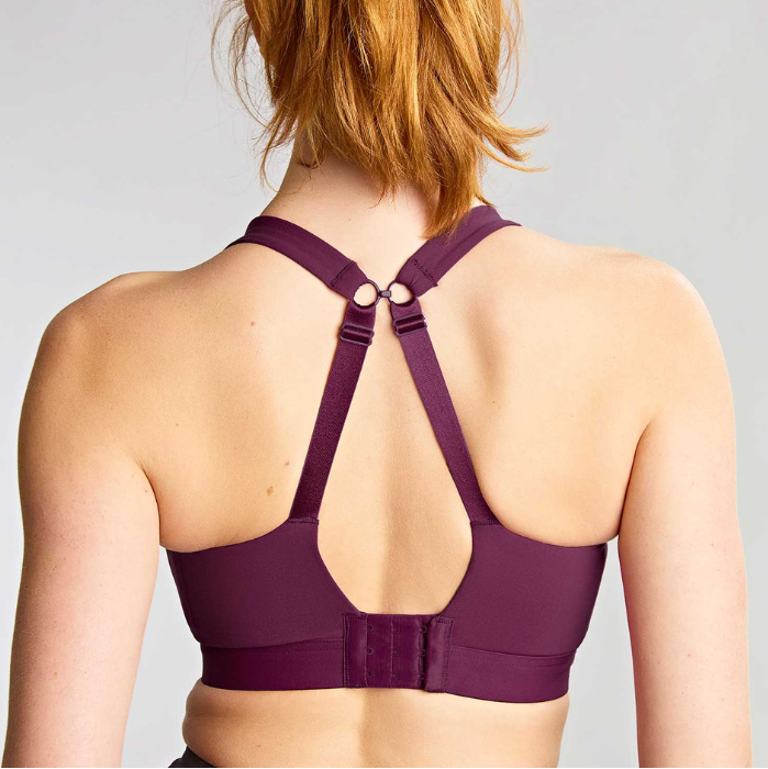 Person wearing a purple sports bra with a gray background
