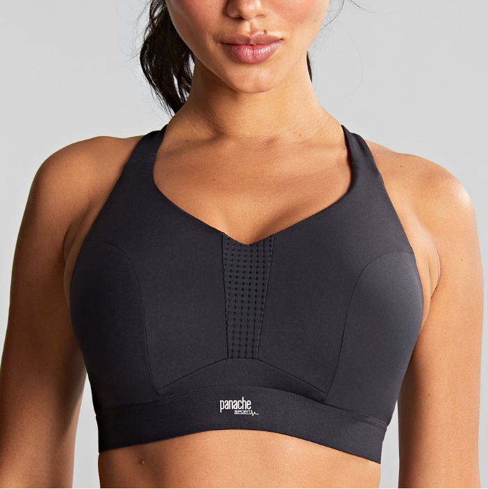 Woman wearing a black sports bra with a gray background