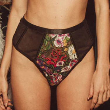 Floral-patterned underwear with sheer mesh panels worn by a person.