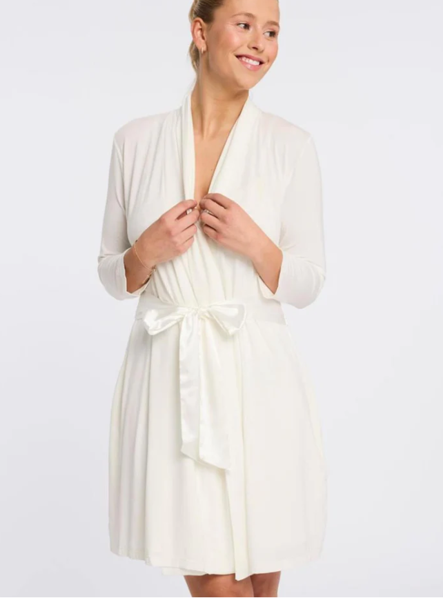 Woman wearing a white robe on a plain background