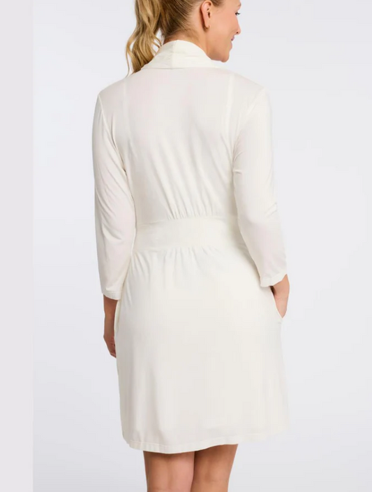 Woman wearing a white robe against a plain background