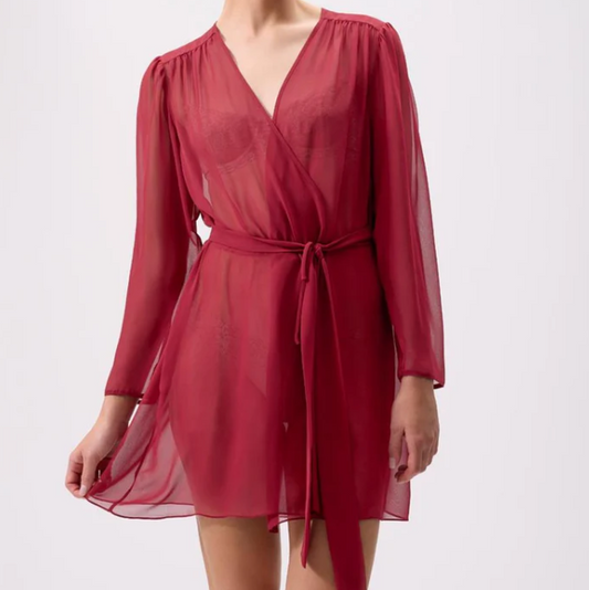 Woman wearing a red robe against a white background