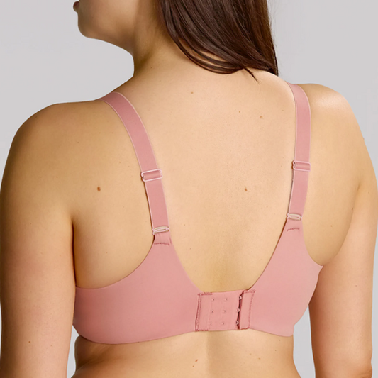 Pink bra worn by a person on a plain background