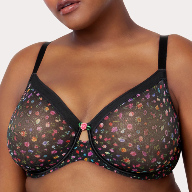 Woman wearing a floral-patterned bra against a neutral background