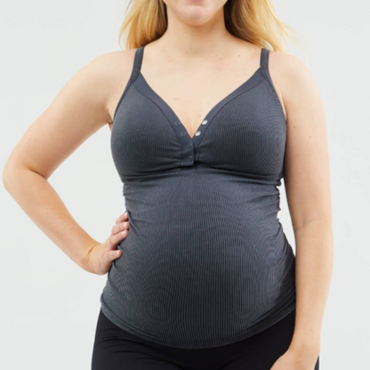 Woman wearing a gray tank top and black leggings on a white background