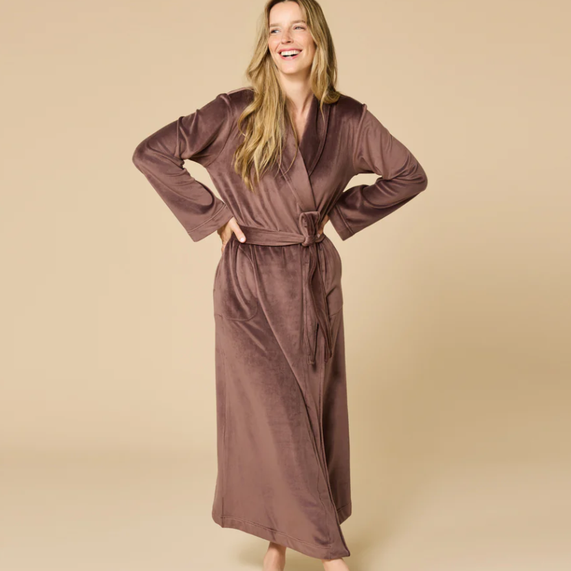 Woman wearing a brown robe against a beige background