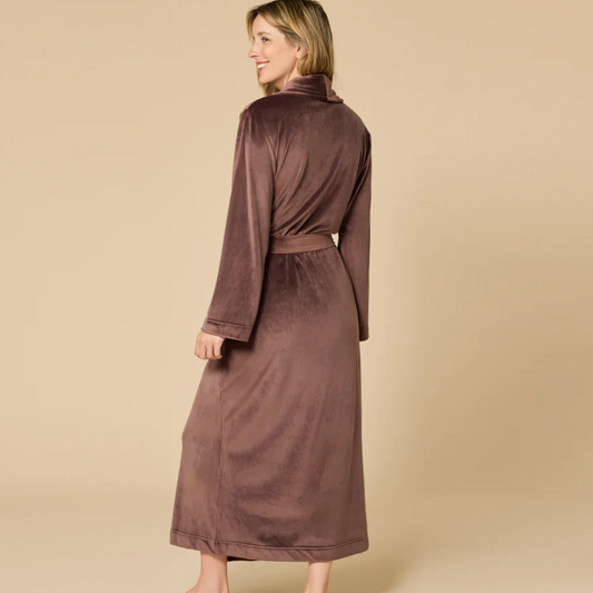 Woman wearing a brown robe against a beige background