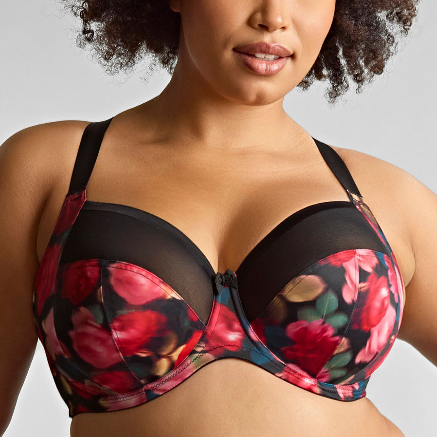 Woman wearing a floral-patterned bra against a neutral background